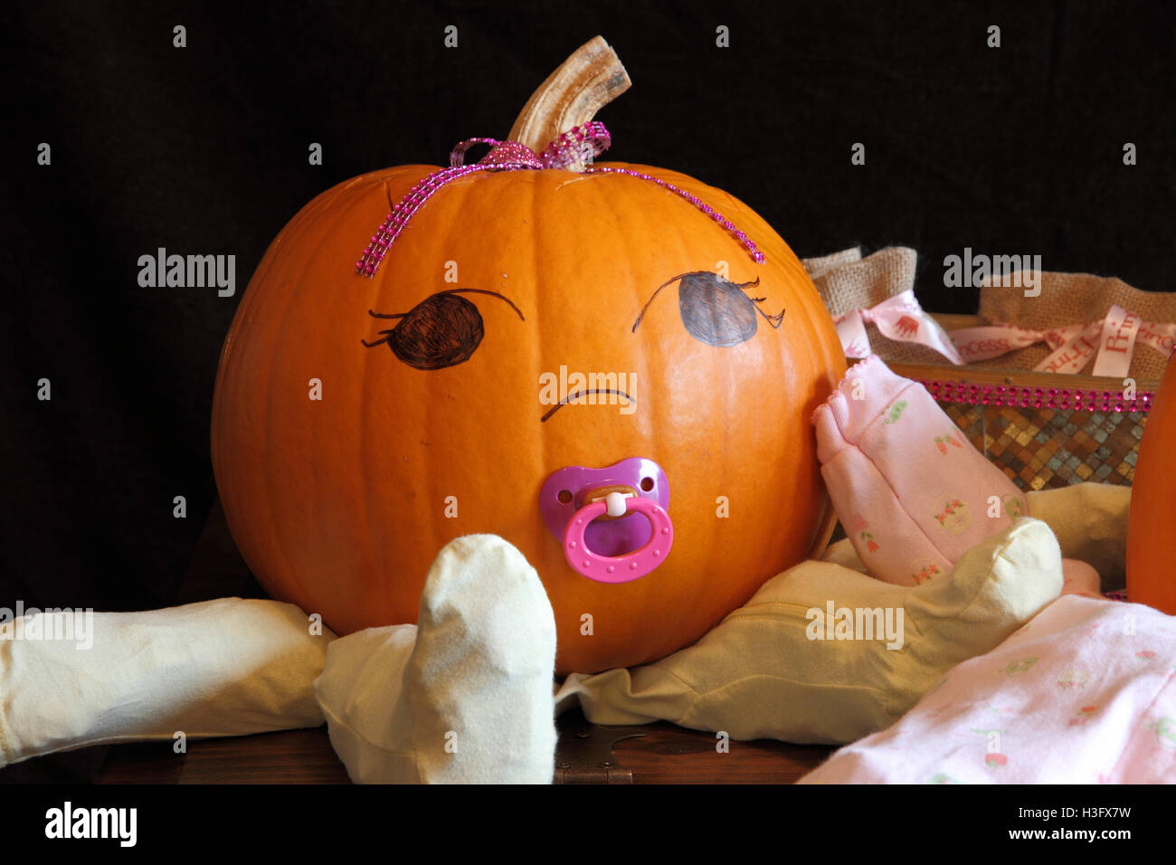 A cute and round pumpkin dressed up like a baby Stock Photo