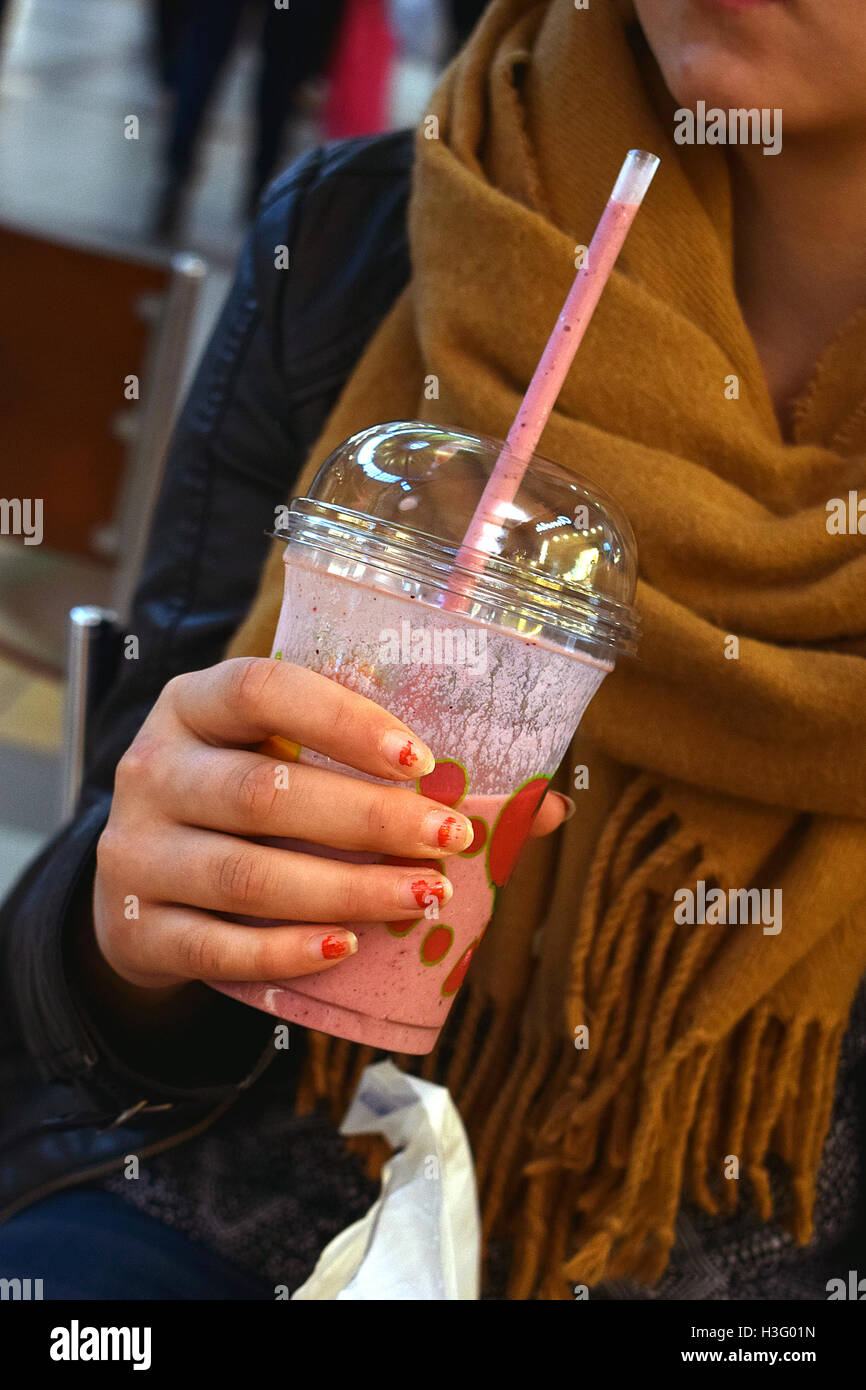 Teen holding a raspberry smoothie. Stock Photo