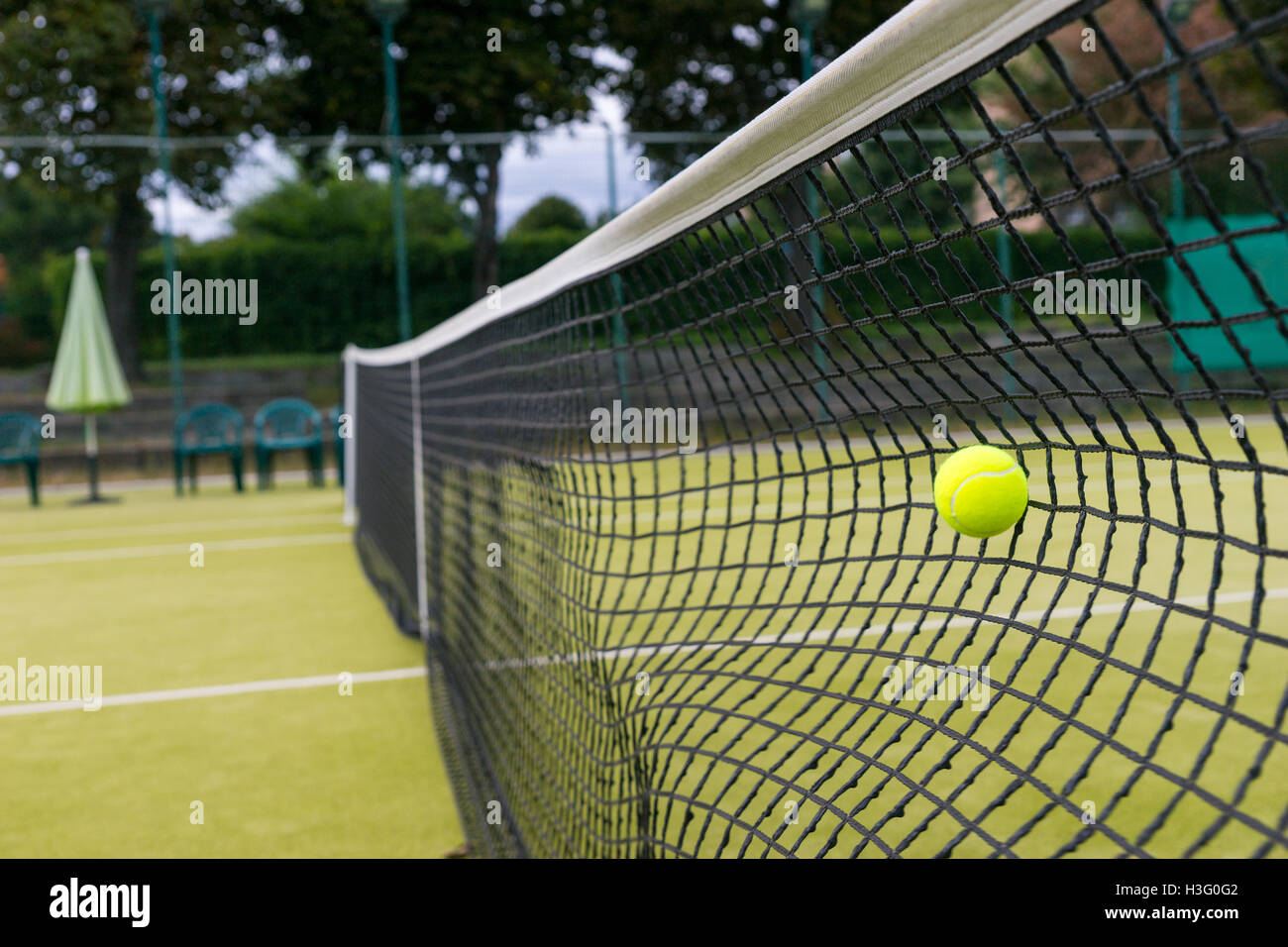 Tennis ball hit the net during the game on a court outdoor in summer or