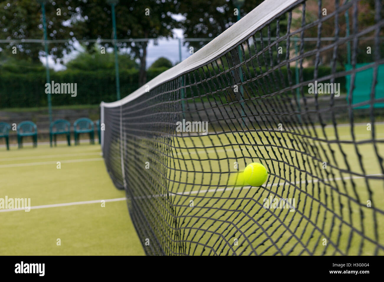 Tennis ball hit the net during the match on a court outdoor in summer