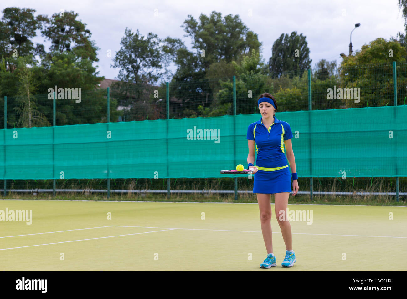 Female tennis player wearing a sportswear holding a tennis ball on her