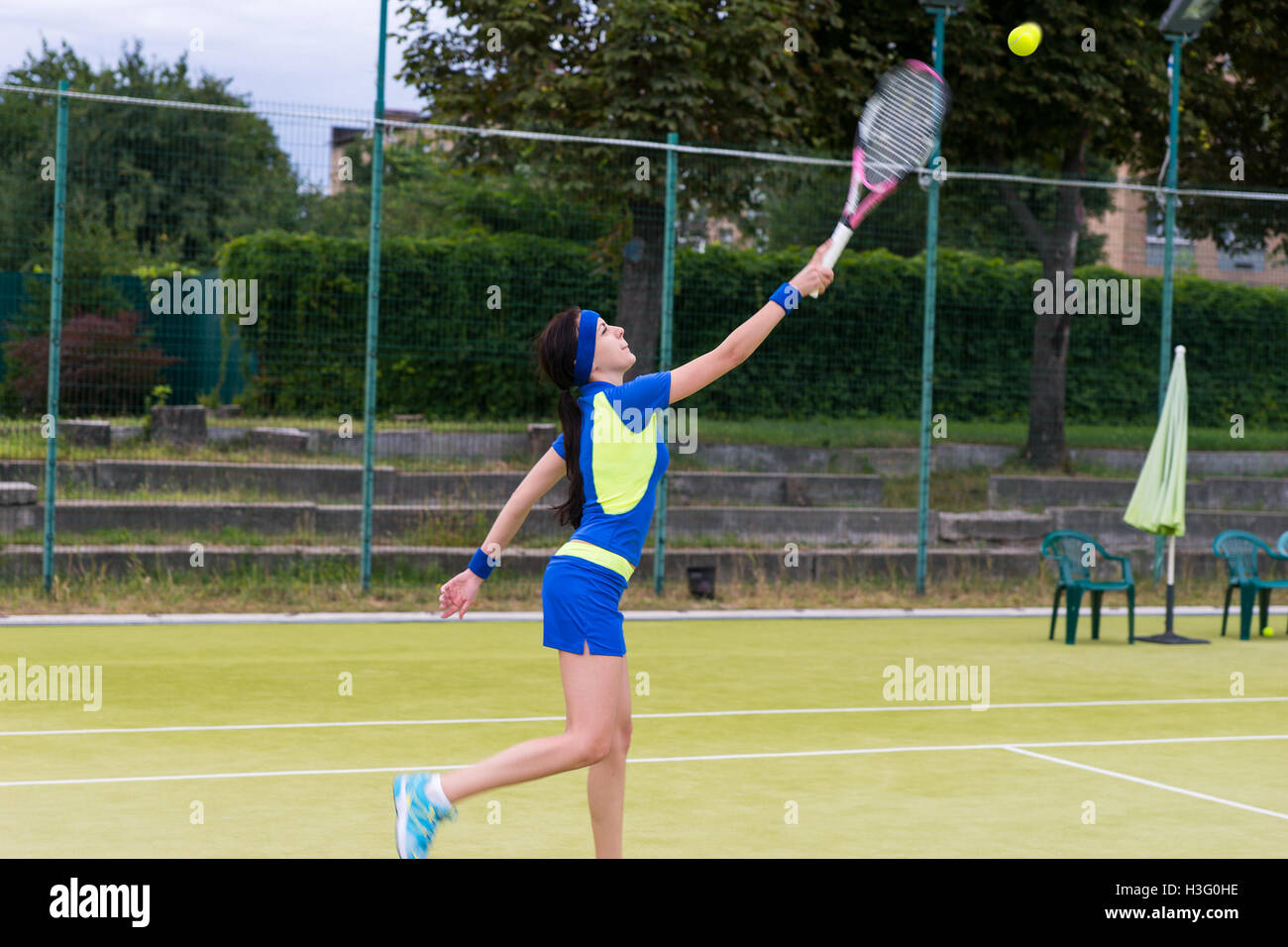 Female tennis player wearing a sportswear returns a ball during a match