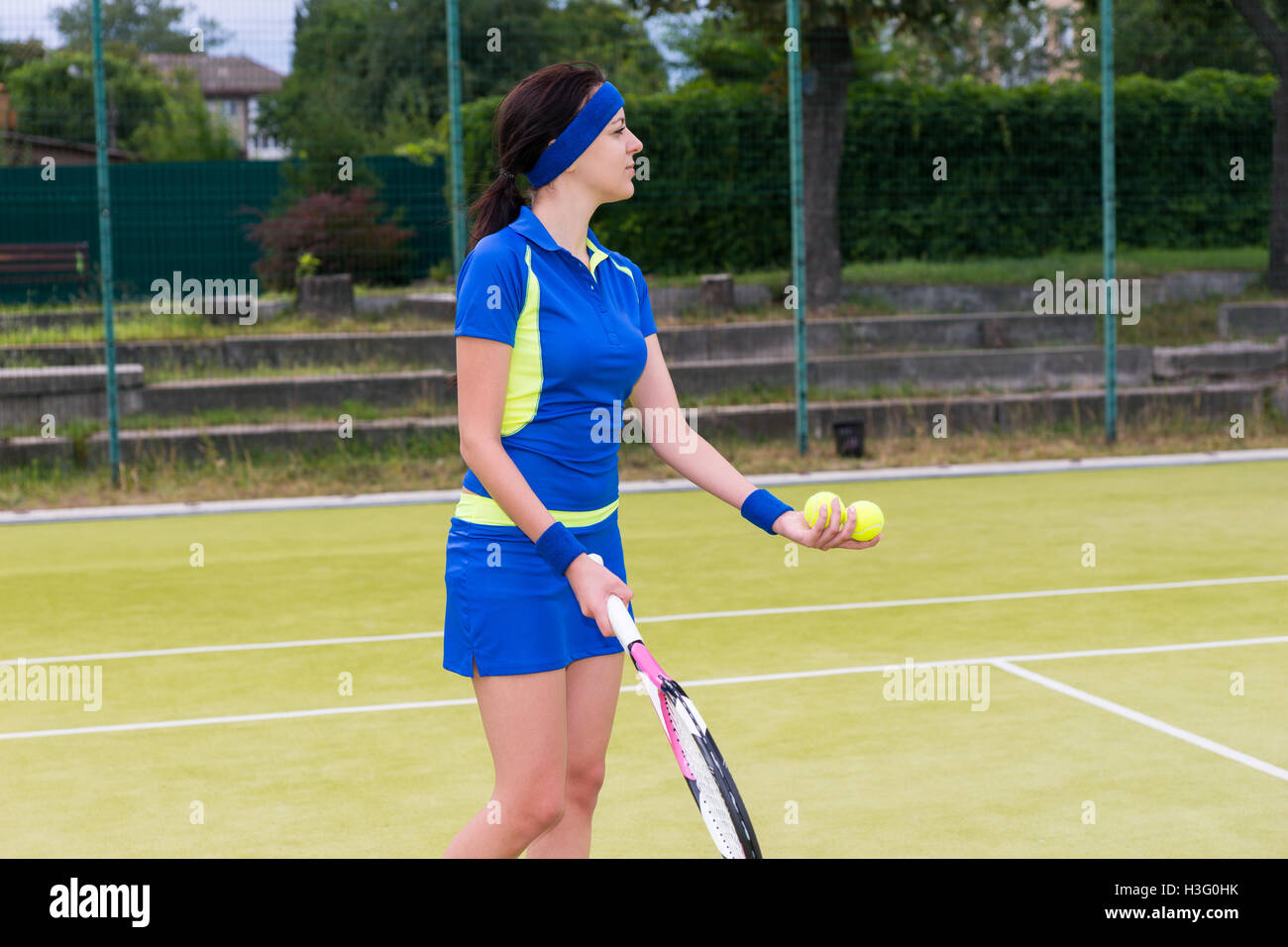 Young sportswoman wearing a sportswear holding tennis balls and a