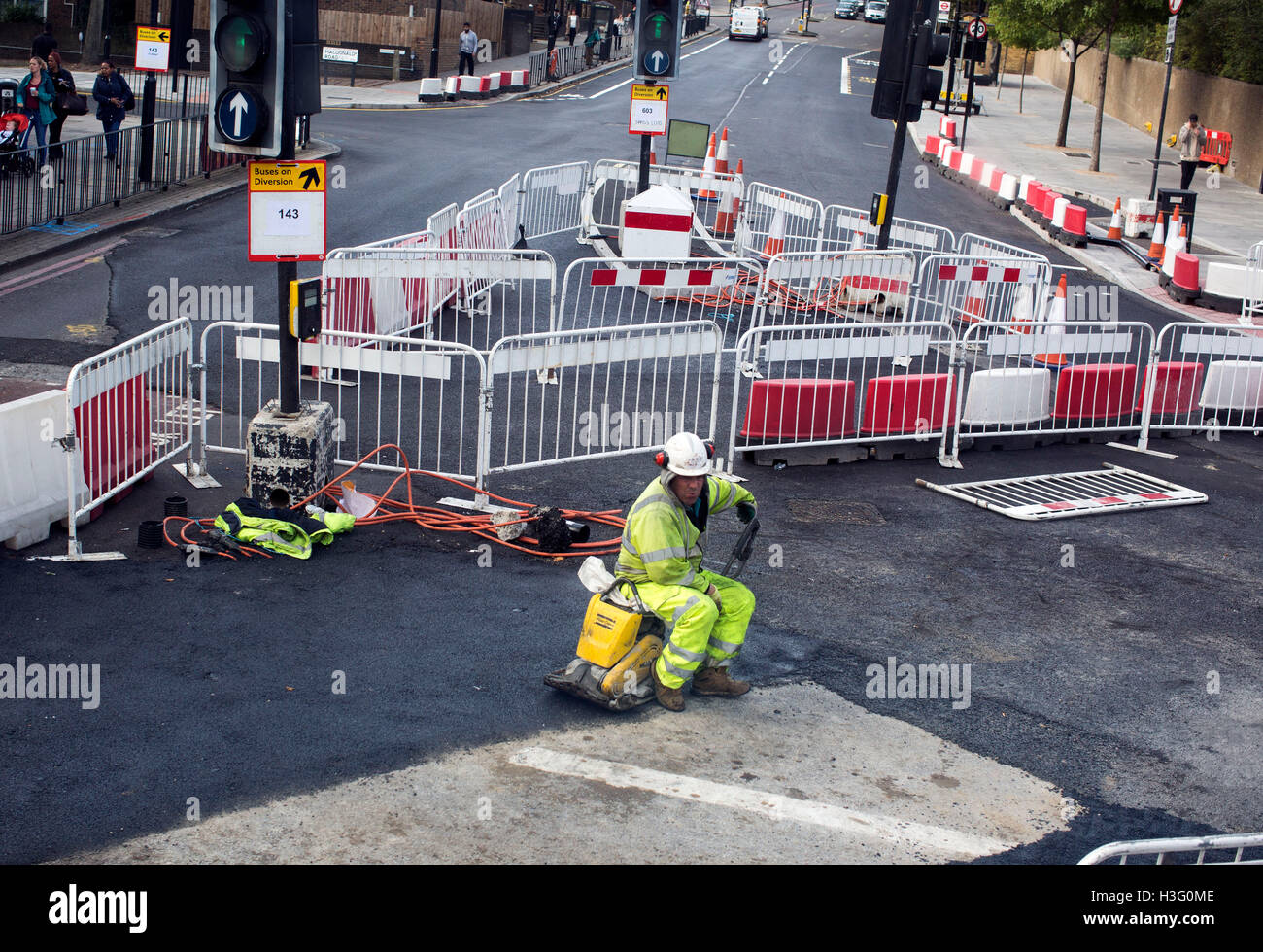roadworks worker sitting down doing nothing resting Stock Photo