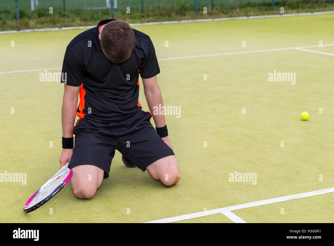 Young male player wearing a sportswear is upset and fell on his knees