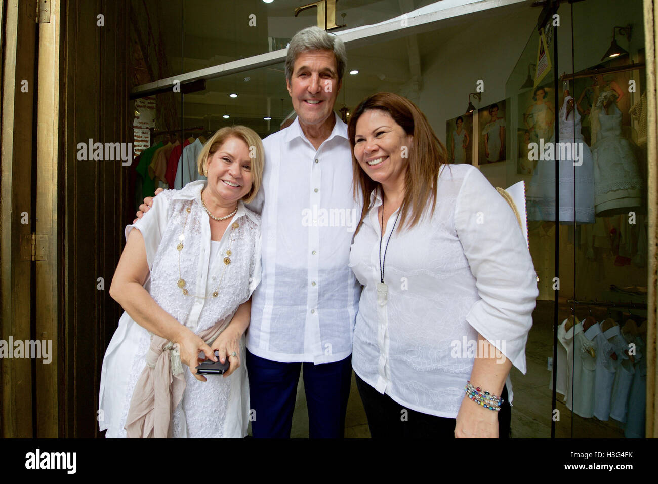 U.S. Secretary of State John Kerry poses for a photo with a store owner who sold him a traditional guayabera shirt after he spotted her while walking through the historic district of Cartagena, Colombia, on September 26, 2016, amid a Mass, working lunch, bilateral meetings, and a peace ceremony between the government and the Revolutionary Armed Forces of Colombia (FARC) that ends a five-decade conflict. Stock Photo