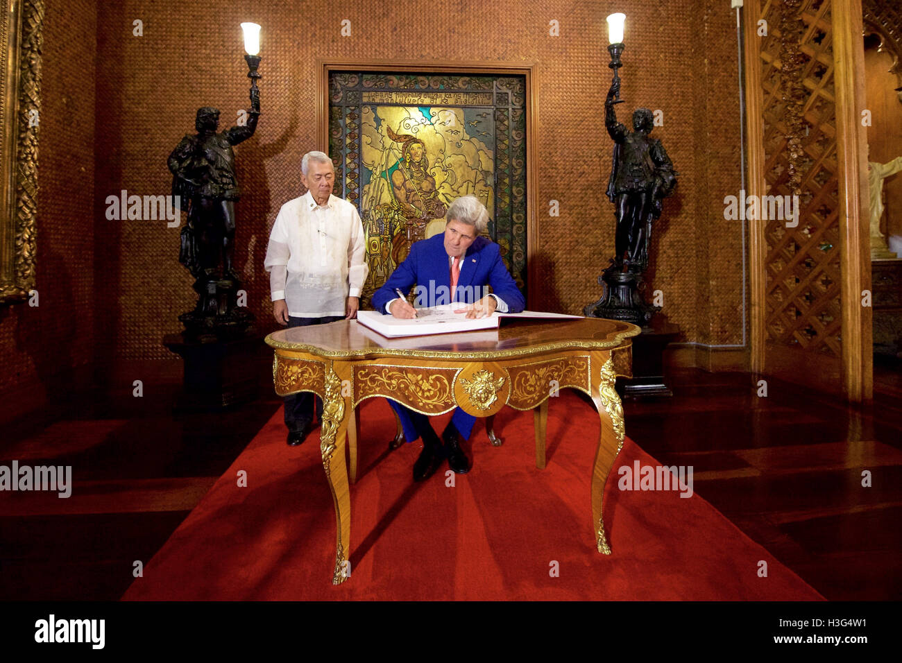 Philippines Foreign Secretary Perfecto Yasay watches as U.S. Secretary of State John Kerry signs the guestbook in the Malacañang Palace in Manila, Philippines, on July 27, 2016, before the Secretary held a working lunch with Philippines President Rodrigo Duterte. Stock Photo