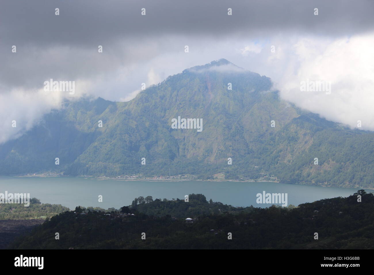 A view of a mountain under the clouds in front of a lake Stock Photo