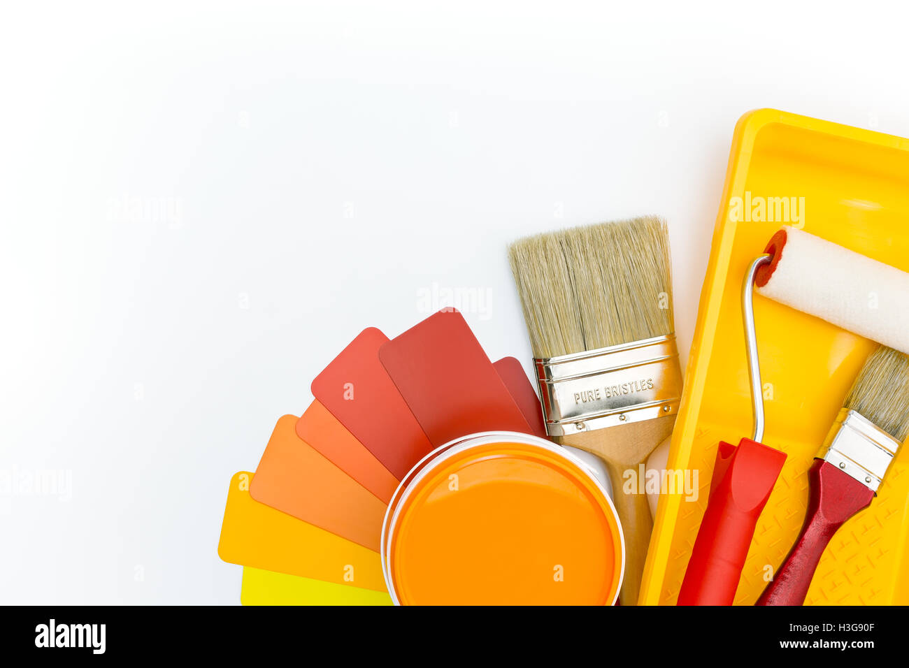 paint roller in tray, brushes, and paint can with color guide Stock