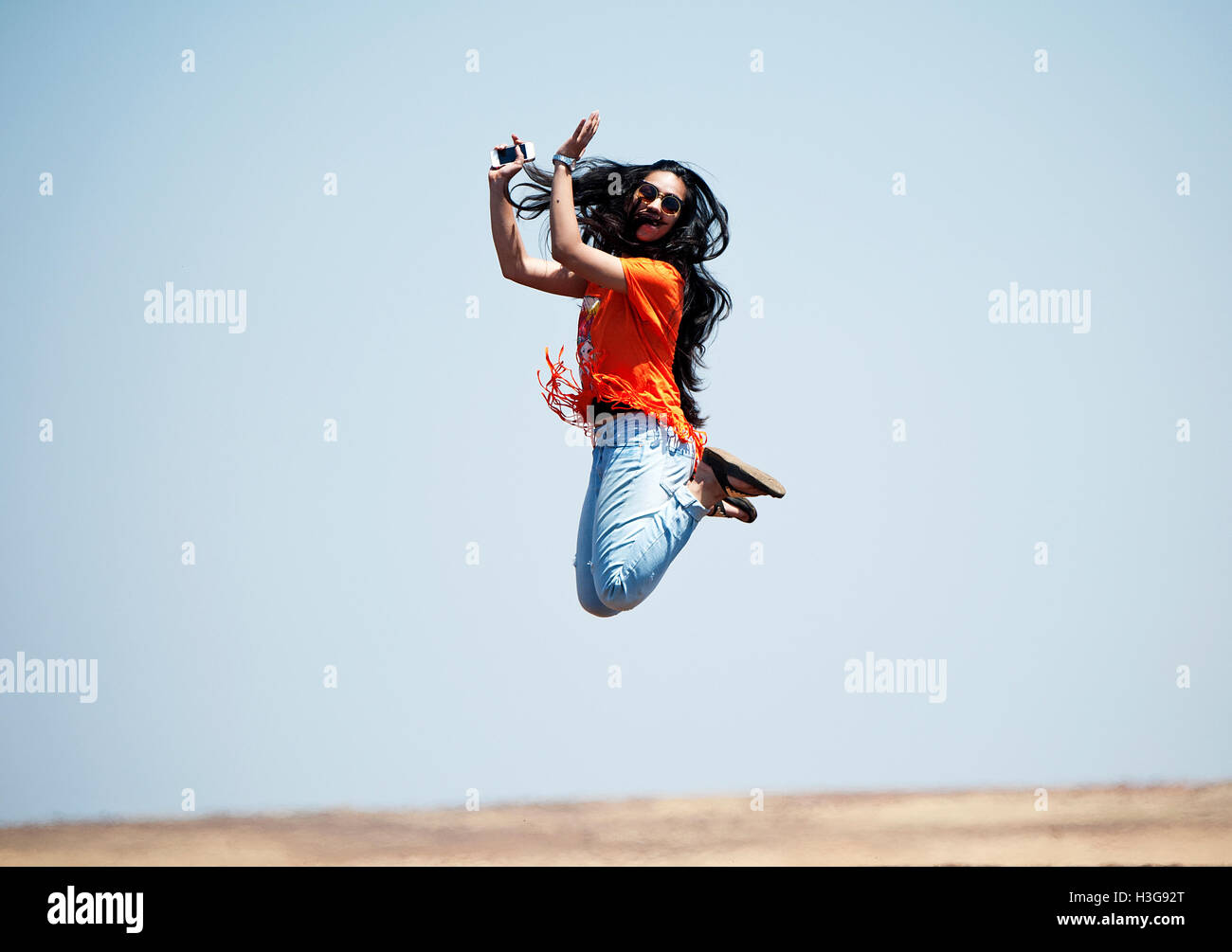 The image of Indian teenage girl jumping up in the air, India Stock