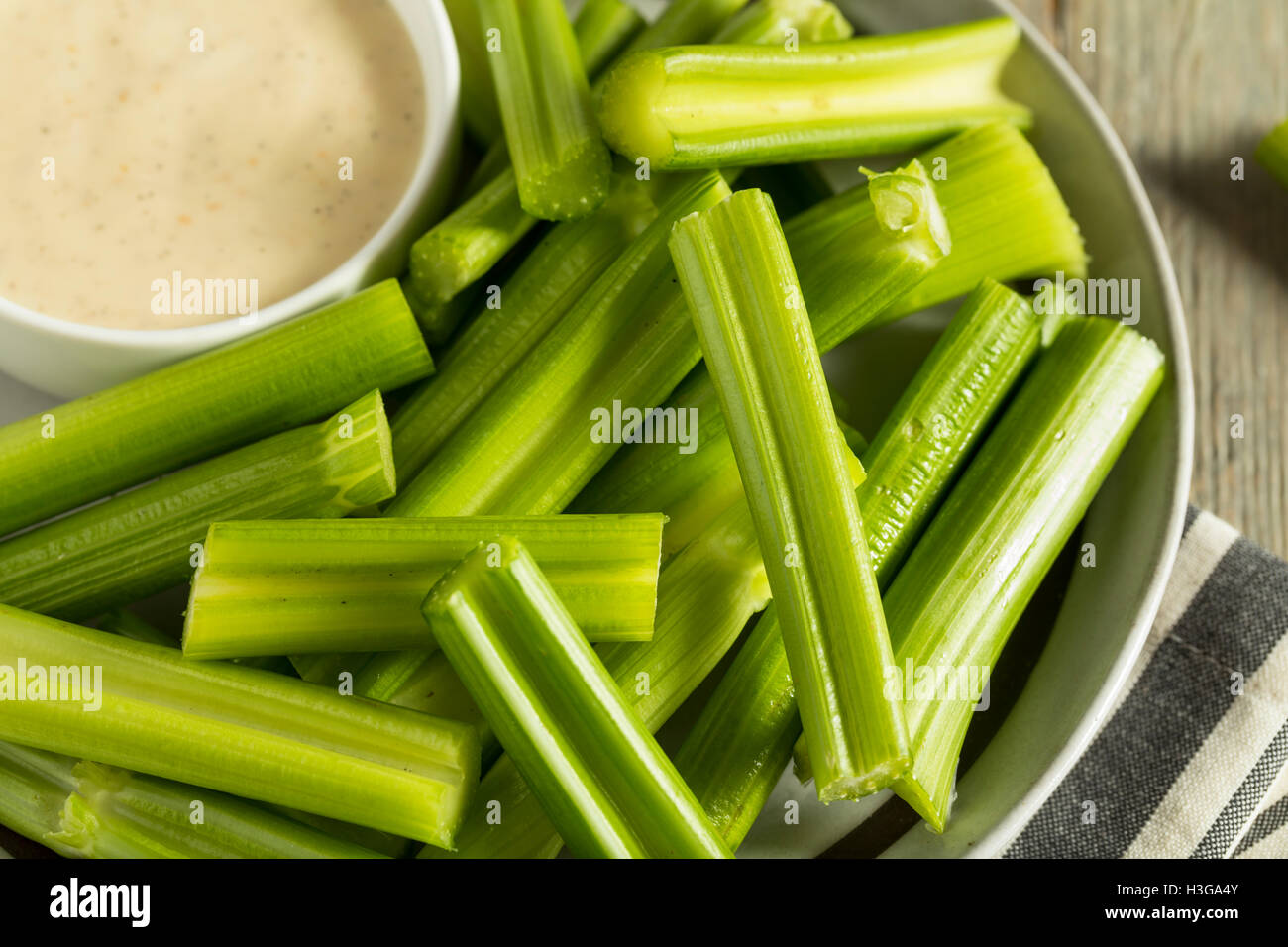 Raw Organic Green Celery Stalks with Ranch Dip Stock Photo
