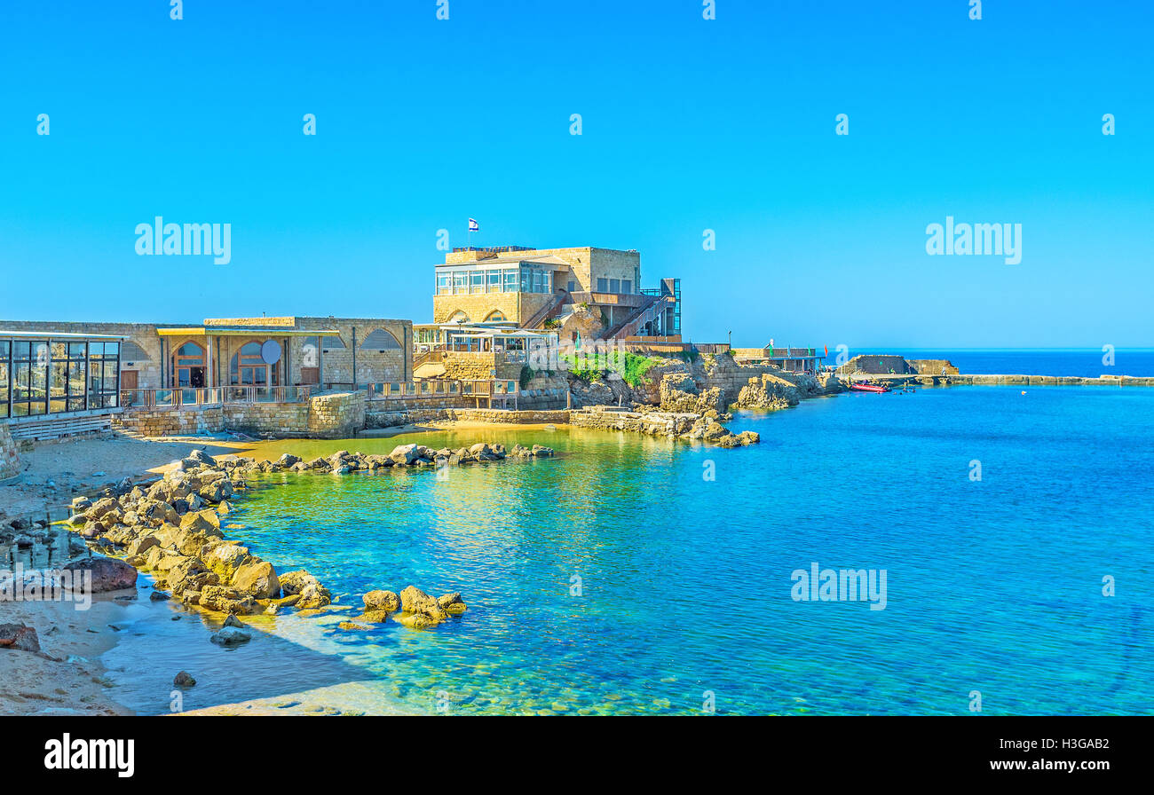 The scenic harbor surrounded by the cozy cafes and luxury restaurant, offering fine local cuisine, Caesarea, Israel. Stock Photo