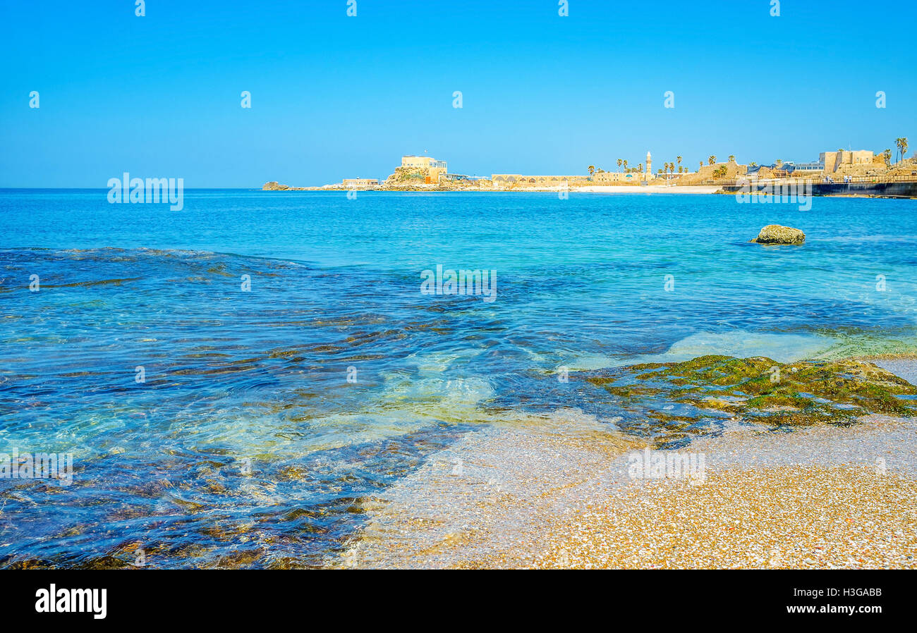 The comfortable beach in Caesarea with the picturesque view on the ancient city on the skyline, Israel. Stock Photo