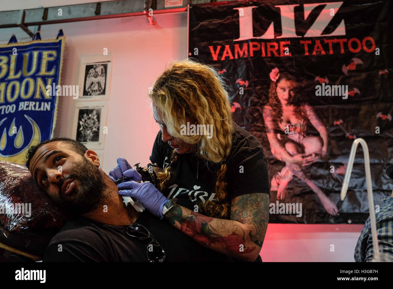 Tel Aviv, Israel. 7th October, 2016. Liz, Vampire Tattoo, tattoos a man's neck. Tattoo and piercing artists from around the world join dozens of leading Israeli artists and visiting enthusiasts at the