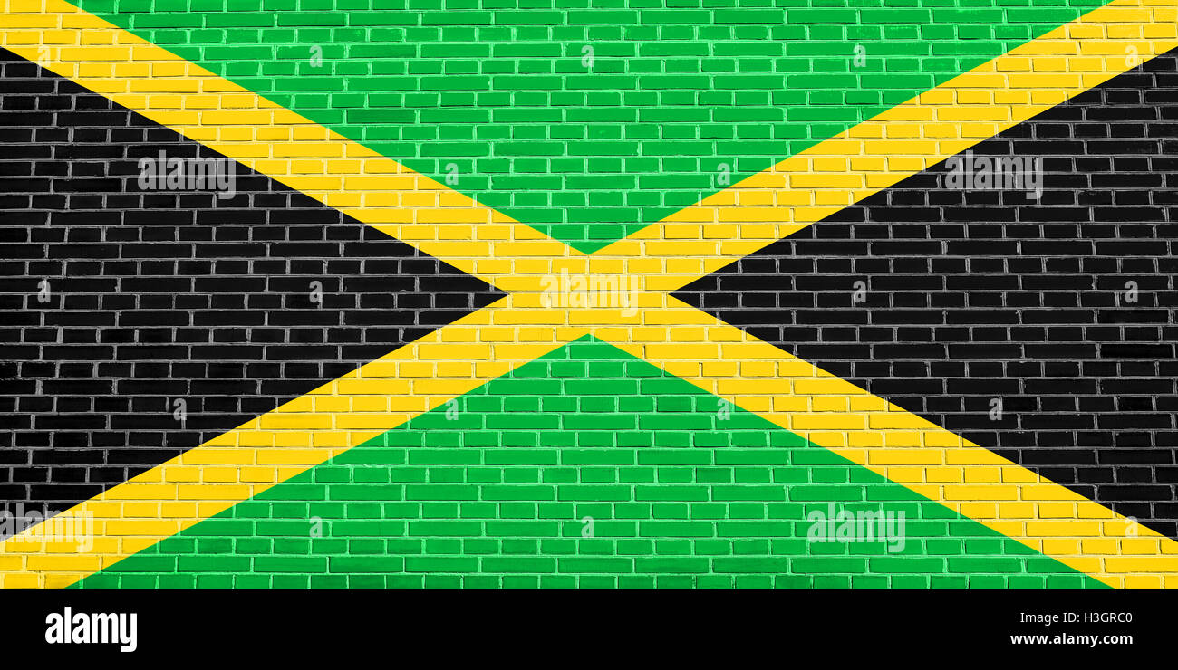 Jamaican national official flag. Patriotic symbol, banner, element, background. Flag of Jamaica on brick wall texture background Stock Photo