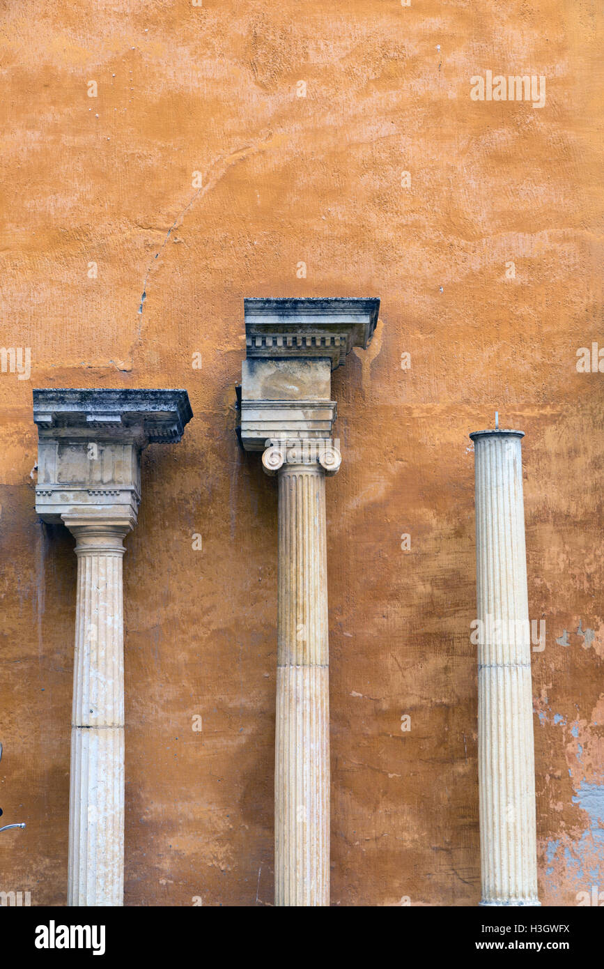 columns and capitals in front of a wall painted ocher Stock Photo