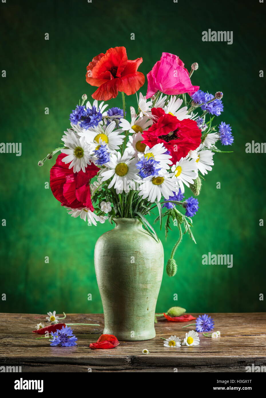 Bouquet of field flowers in the vase on the wooden table. Stock Photo