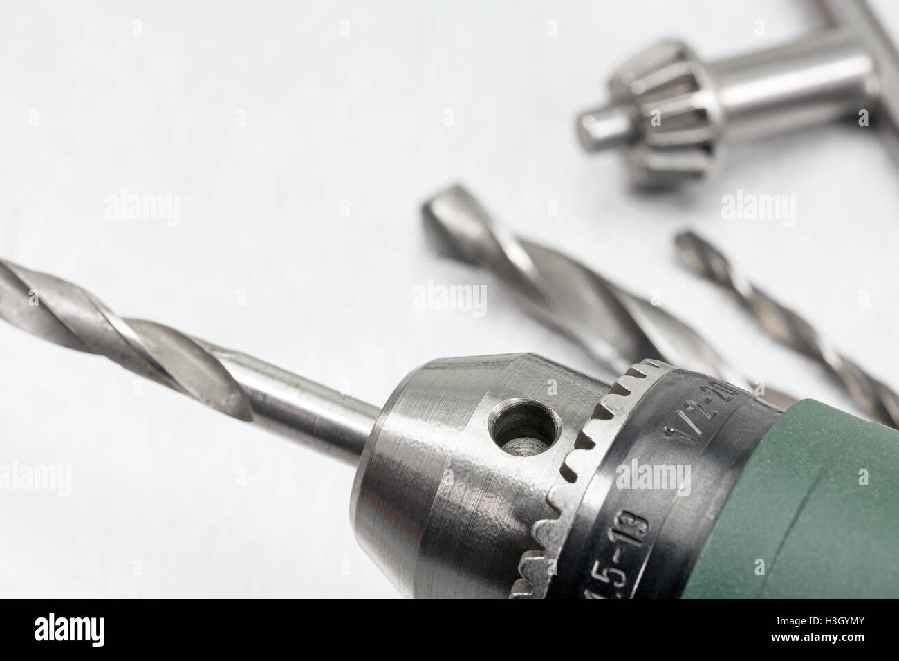 Electric drill head with drill bits and drill key on scratched metal background Stock Photo