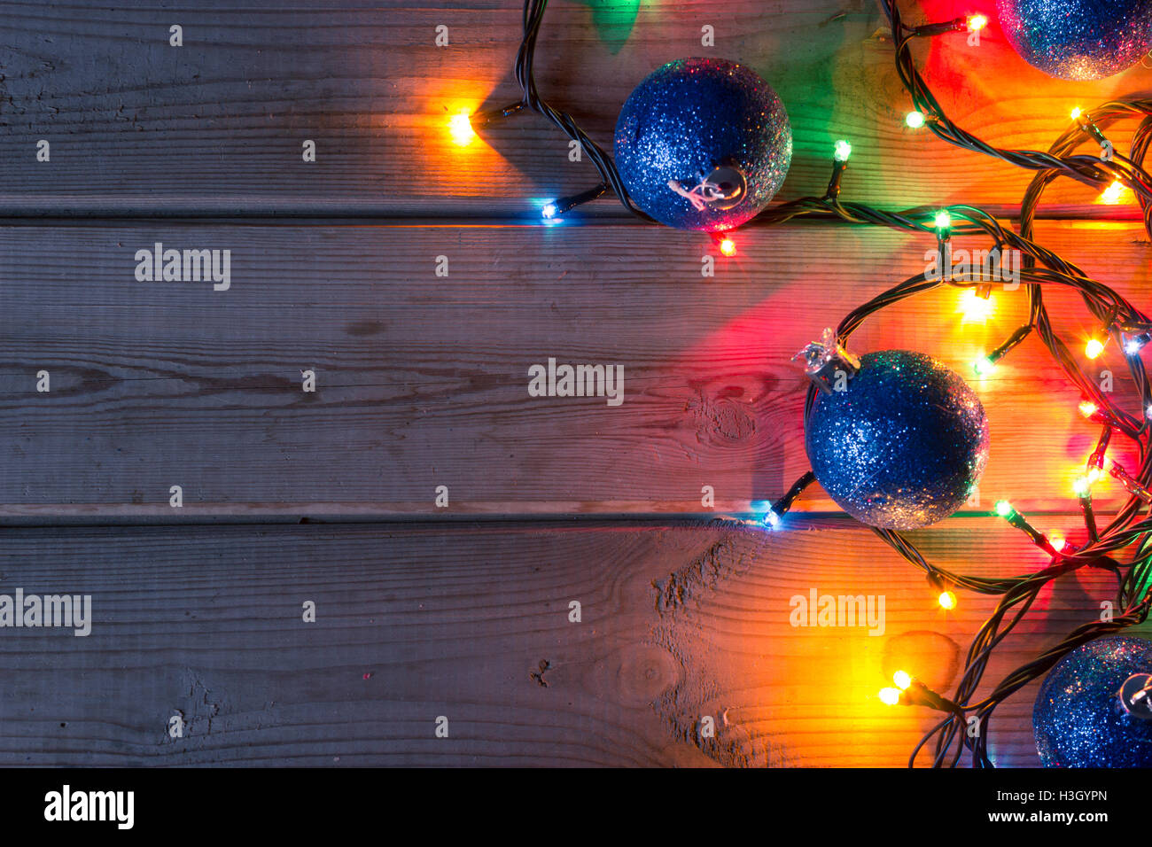 Christmas tree garland, Christmas tree branches and Christmas balls on wooden table mock up