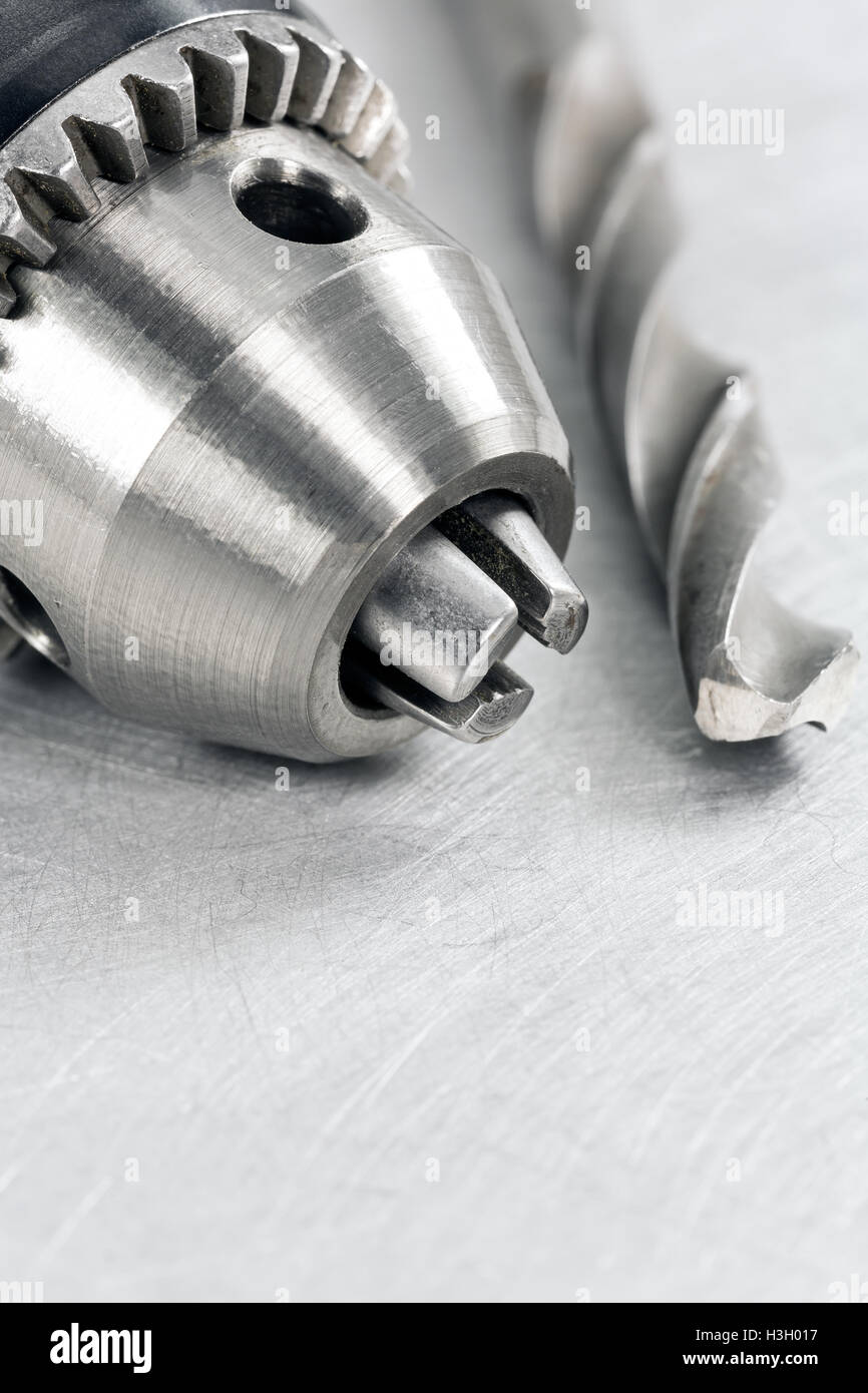 Closeup of drill head with bit on scratched metal background Stock