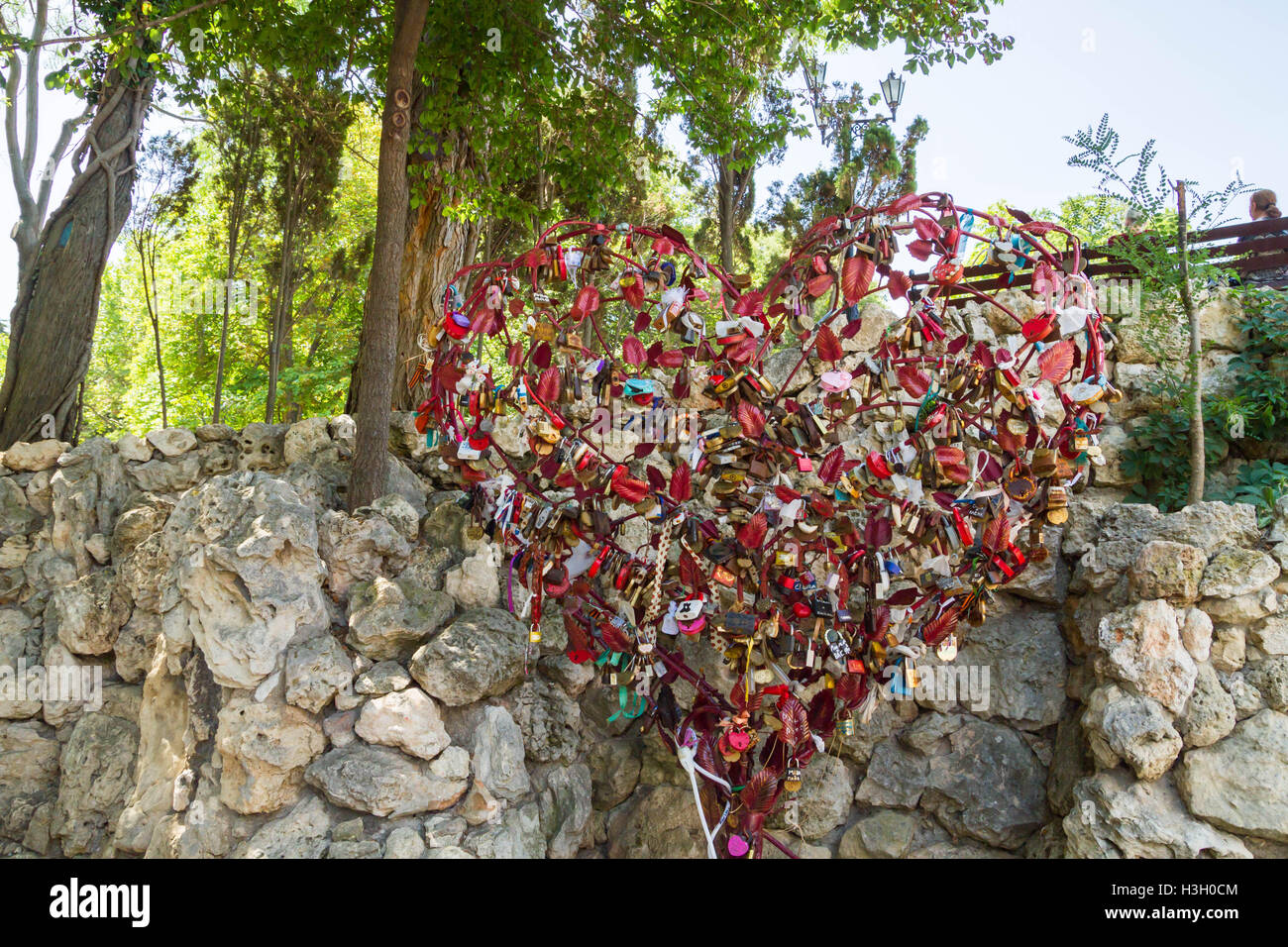 Metallic red heart hung with locks of love Stock Photo - Alamy