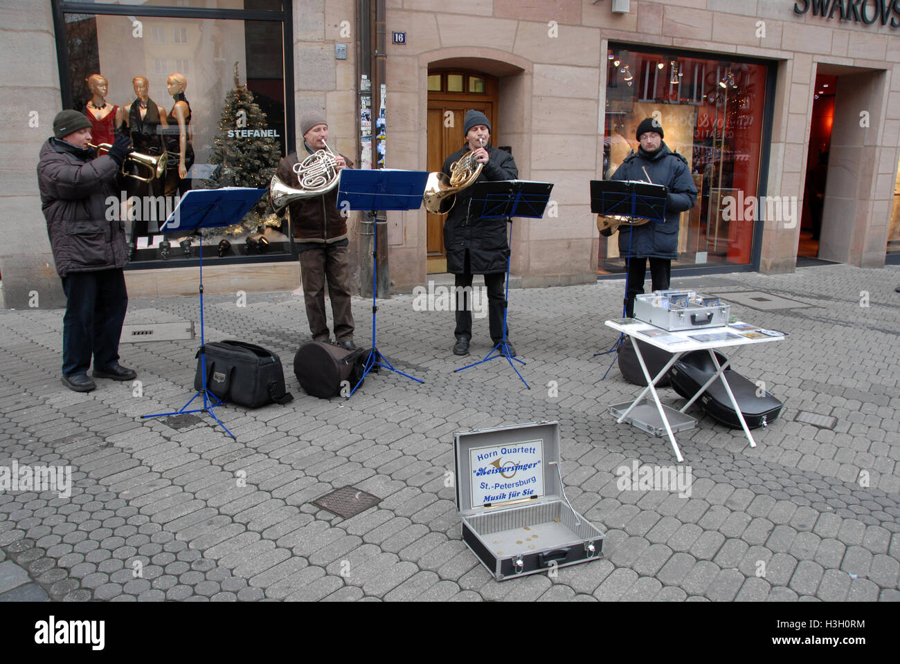 A group of street buskers playing their musical instruments of ...