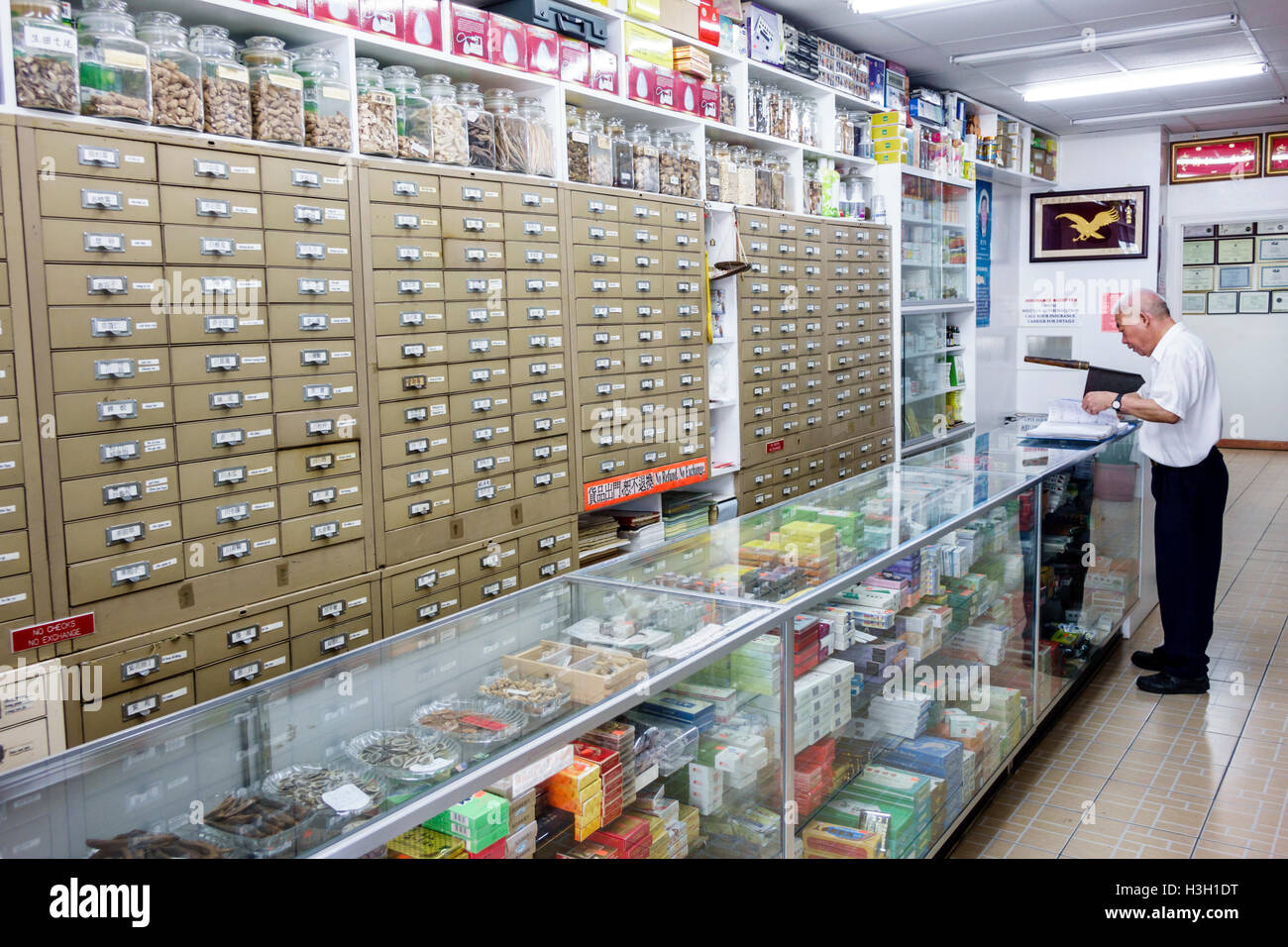 New York City,NY NYC Lower Manhattan,Chinatown,pharmacy,traditional Chinese medicine,herbs,herbal cures,counter,drawers,Asian adult,adults,man men mal Stock Photo
