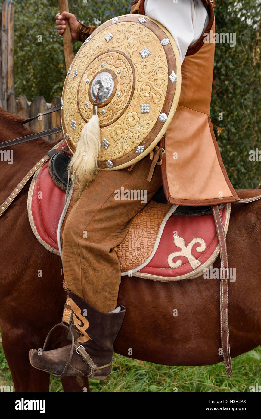 Detail of guard in traditional hun clothes with shield and spear on horseback Kazakhstan Stock Photo