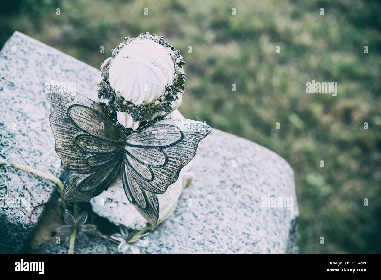 Back view of an angel statue in a cemetary with faded effect Stock Photo