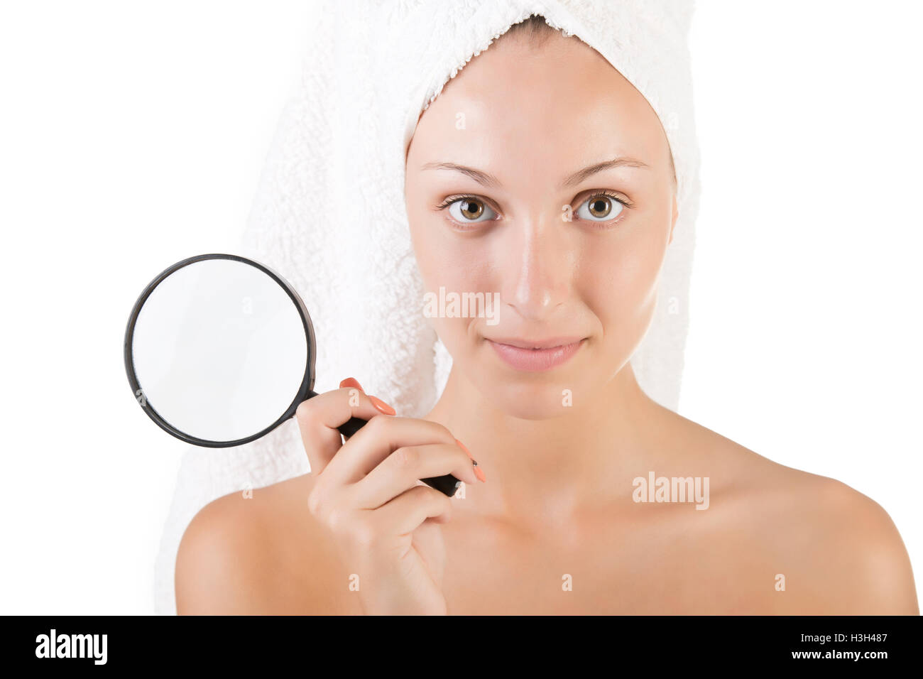 Woman with a towel wrapped around her head holding a loupe, isolated in white Stock Photo