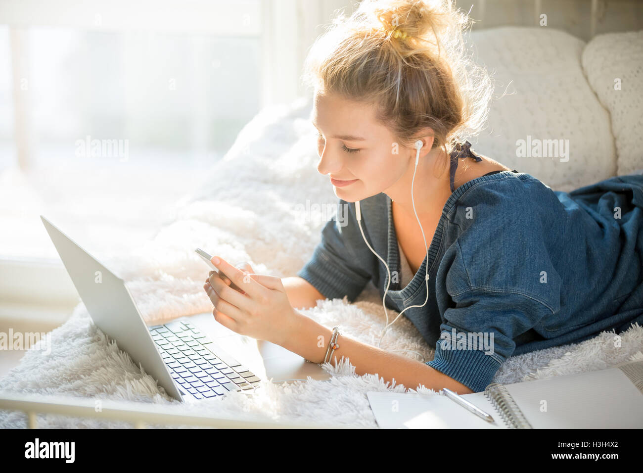 Portrait of an attractive woman lying on bed with laptop Stock Photo ...