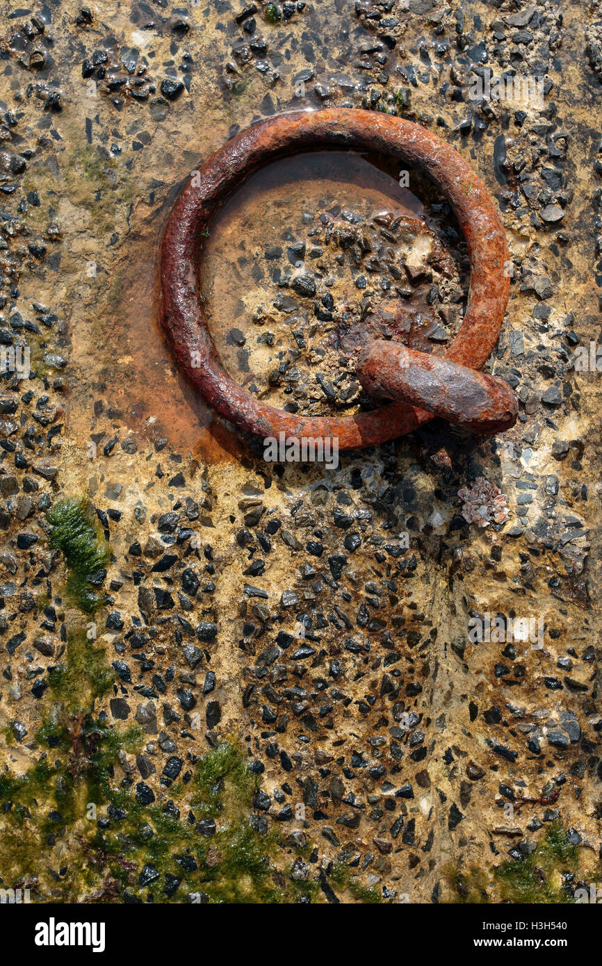 Close Up of Old Rusty Metal Ring at the Harbor used to tow the ships Stock Photo