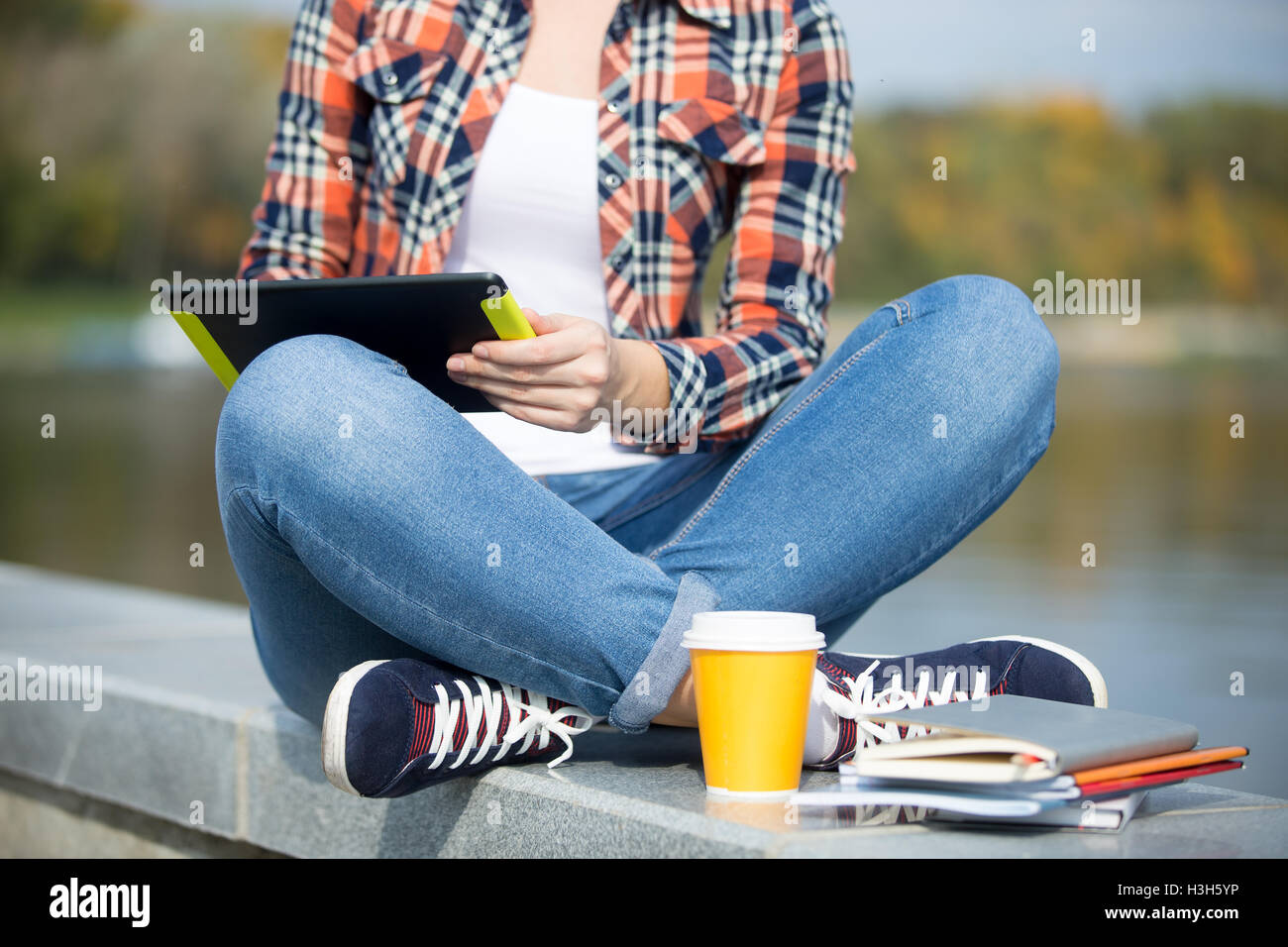 Student sitting turkish at bridge with tablet Stock Photo