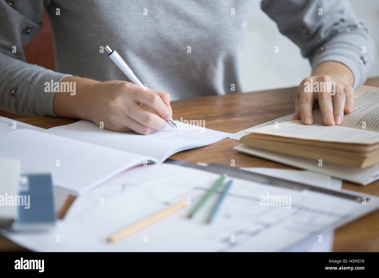 Student female hands performing a written task in a copybook Stock Photo