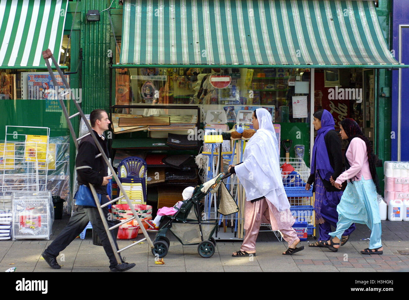 A typical scene in Stratford Road, Birmingham, with a white window cleaner passing a group of Moslem women in this mixed race neighbourhood. Stock Photo