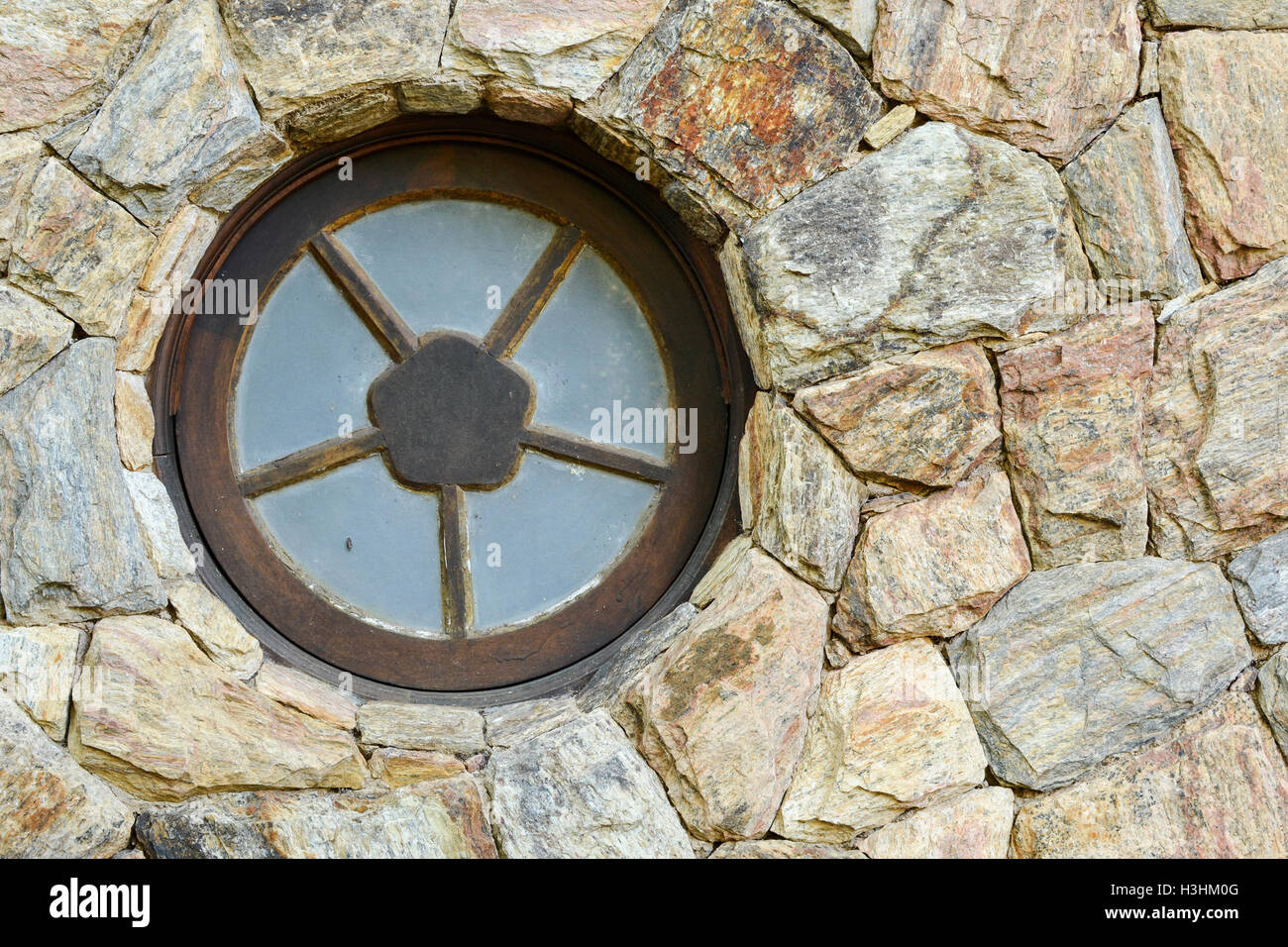 A Round metal window on the stone wall of an unidentified residence ...