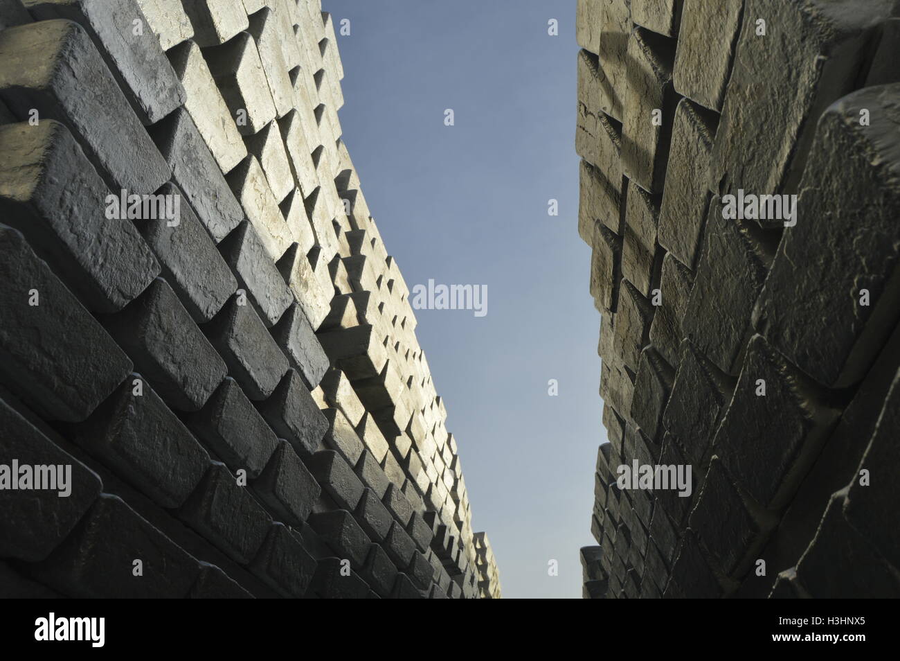 Lot of primary aluminum ingots with blue sky background. Stock Photo