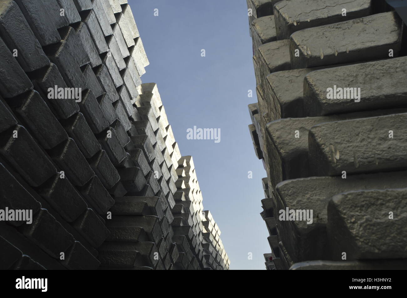 Lot of primary aluminum ingots with blue sky background. Stock Photo