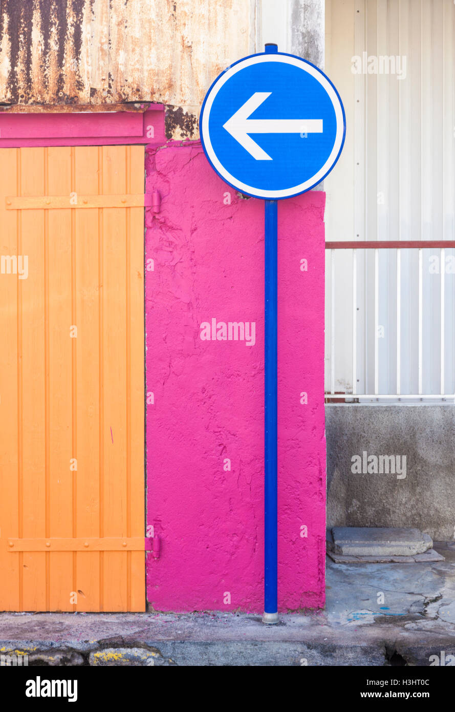 One way sign in front of vibrant pink wall at Guadeloupe Stock Photo