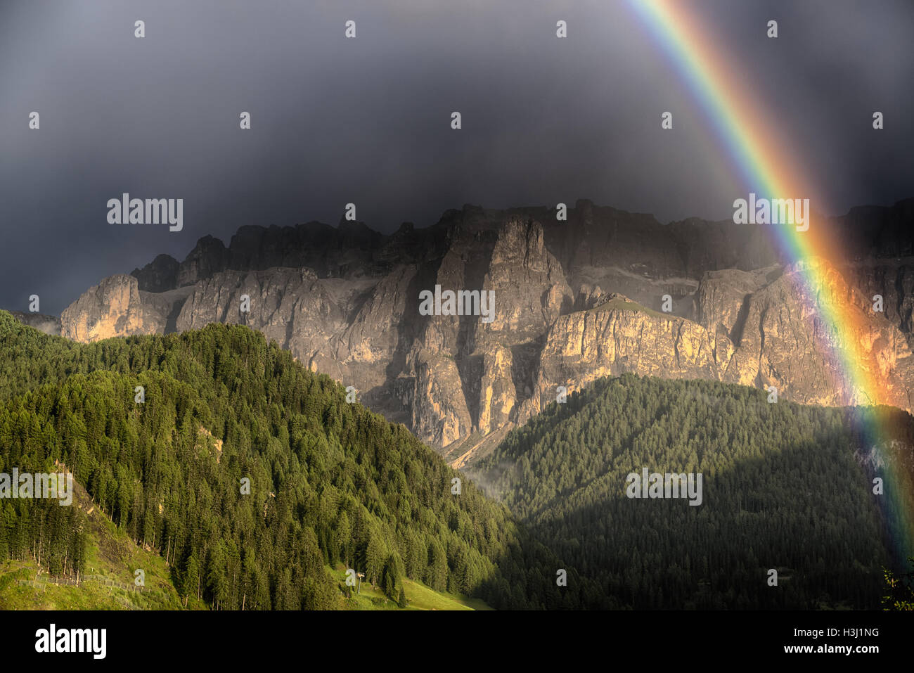 Rainbow after the thunderstorm over the hills and mountains of Selva di Val Gardena in a summer day, Trentino-Alto Adige - Italy Stock Photo