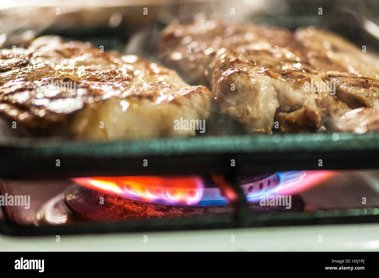 Closeup on grilled pork steaks in a frying pan Stock Photo