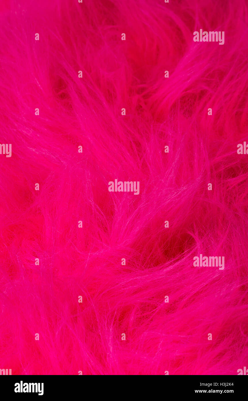 Pink plush fabric vertical. Very soft polyester textile made of synthetic fibers with long hairs. Macro close up photo. Stock Photo