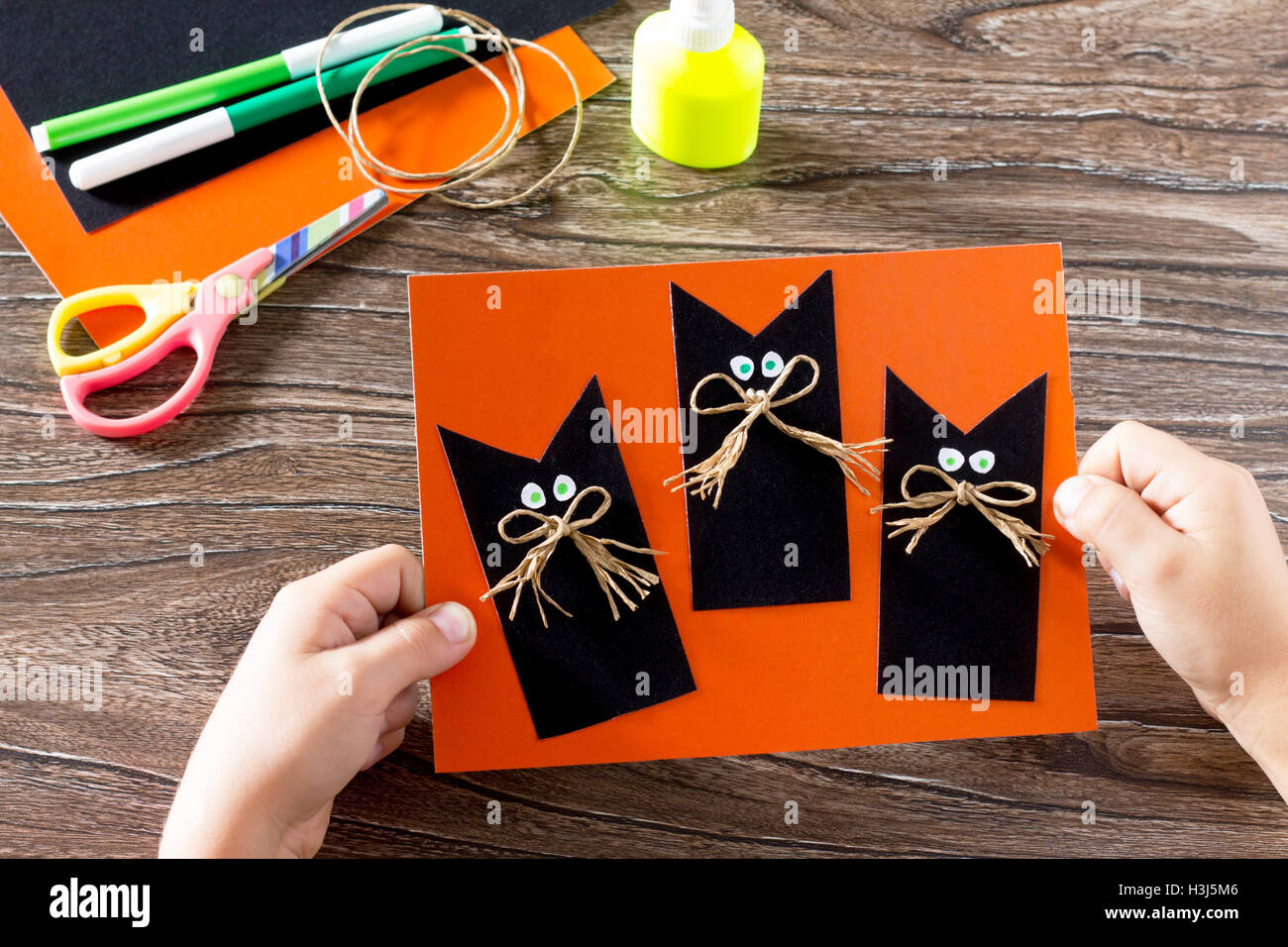 the-child-create-a-greeting-card-halloween-black-cat-out-of-paper-glue-scissors-leaves-velvet