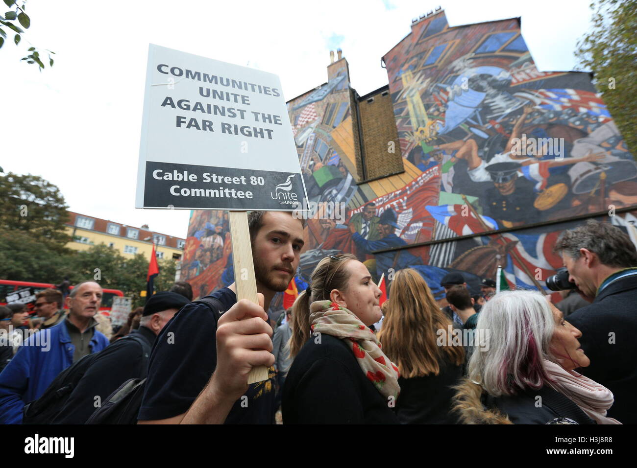 Cable Street Sign Demonstrators pass by a mural on Cable Street in the East End of London ...