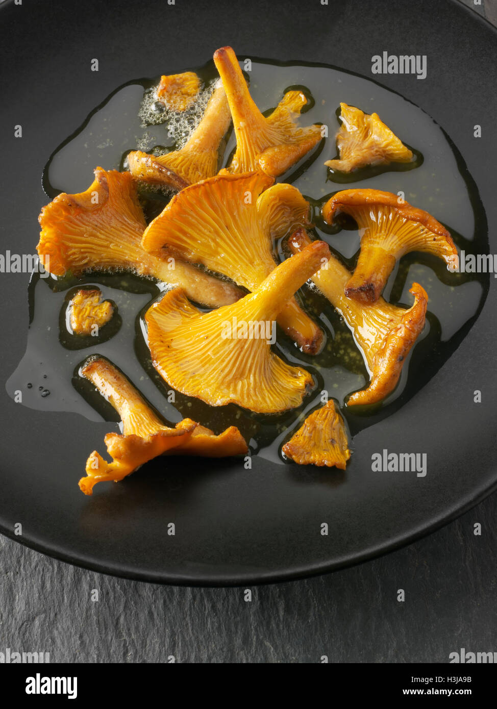 Wiild organic chanterelle or girolle Mushrooms (Cantharellus cibarius) or sauteed in butter Stock Photo