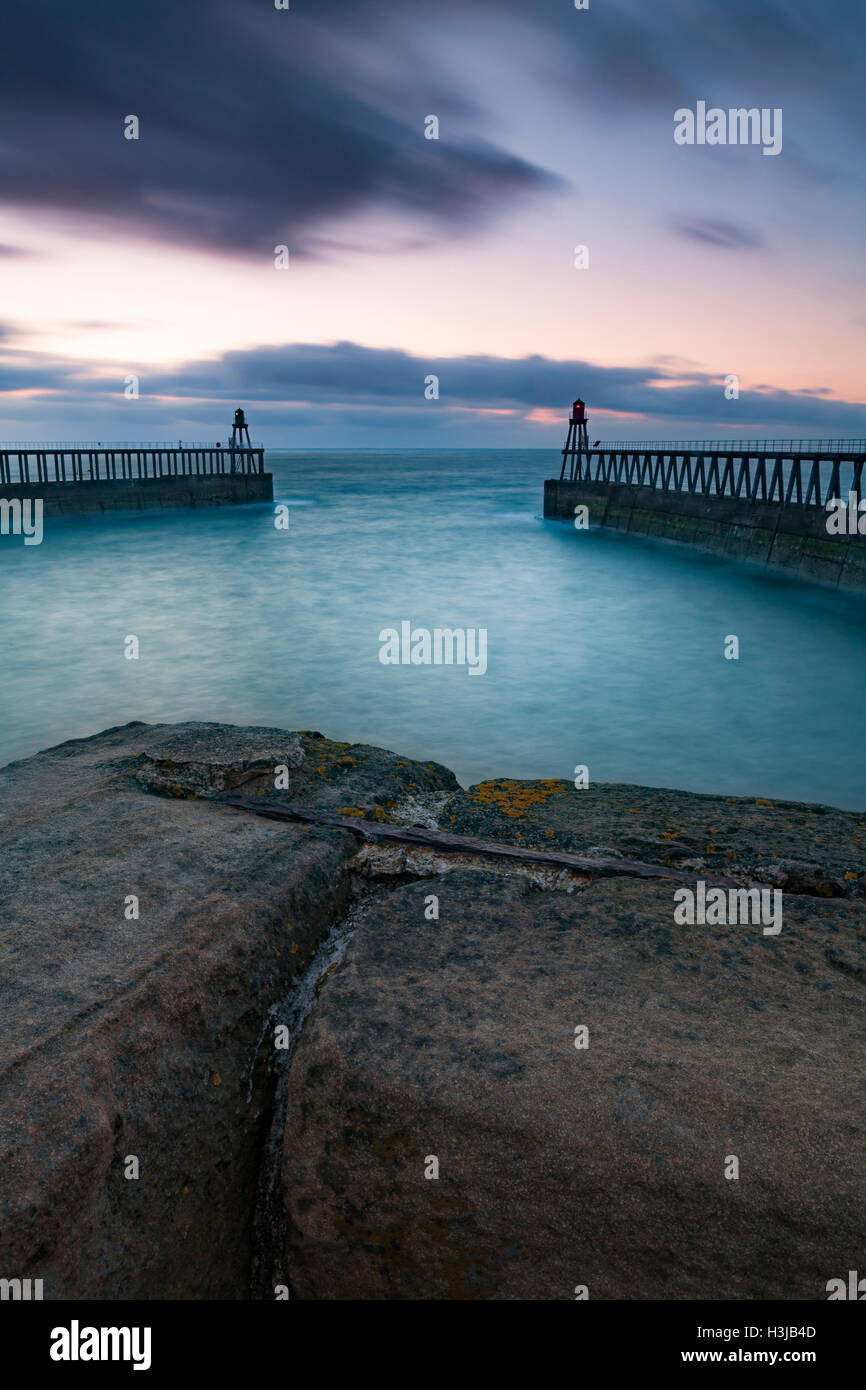 The breakwaters and pier at Whitby, North Yorkshire at sunset. Stock Photo