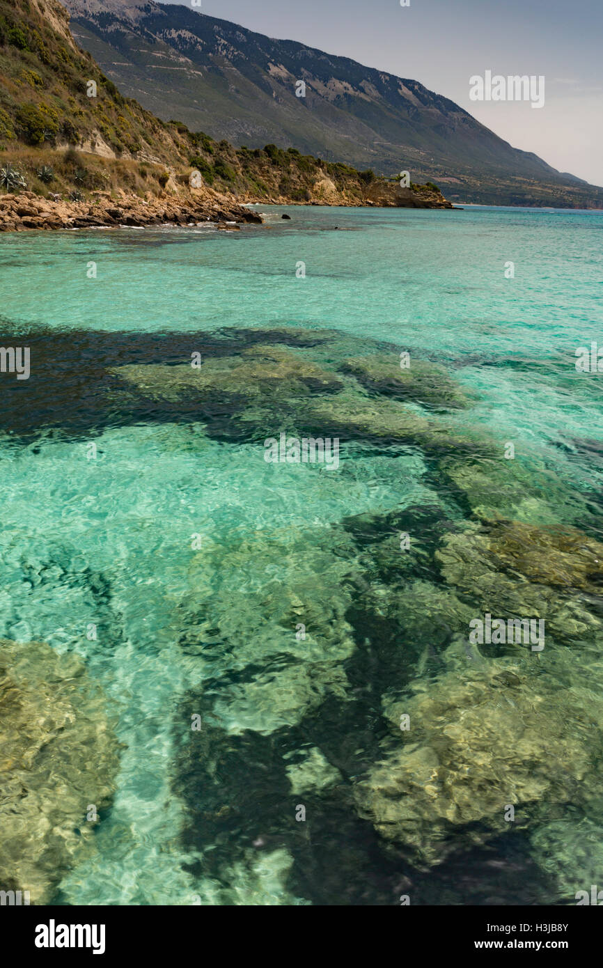 The rocks on Saint Thomas beach, Kefalonia, are visible through the beautiful clear turquoise sea. Stock Photo