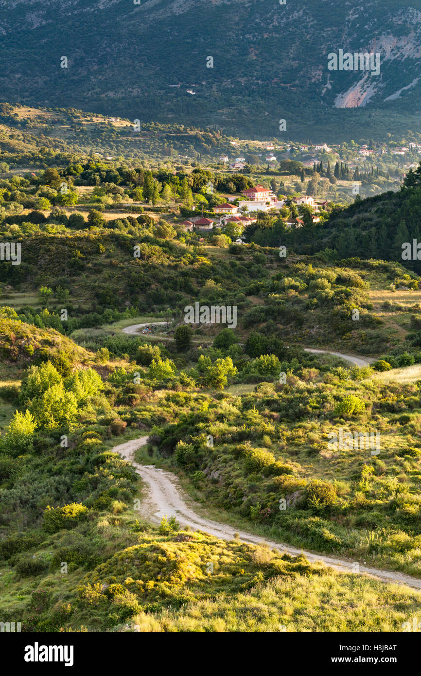 A winding road leads to the village of Agia Eirini, Kefalonia in the early morning sunlight. Stock Photo