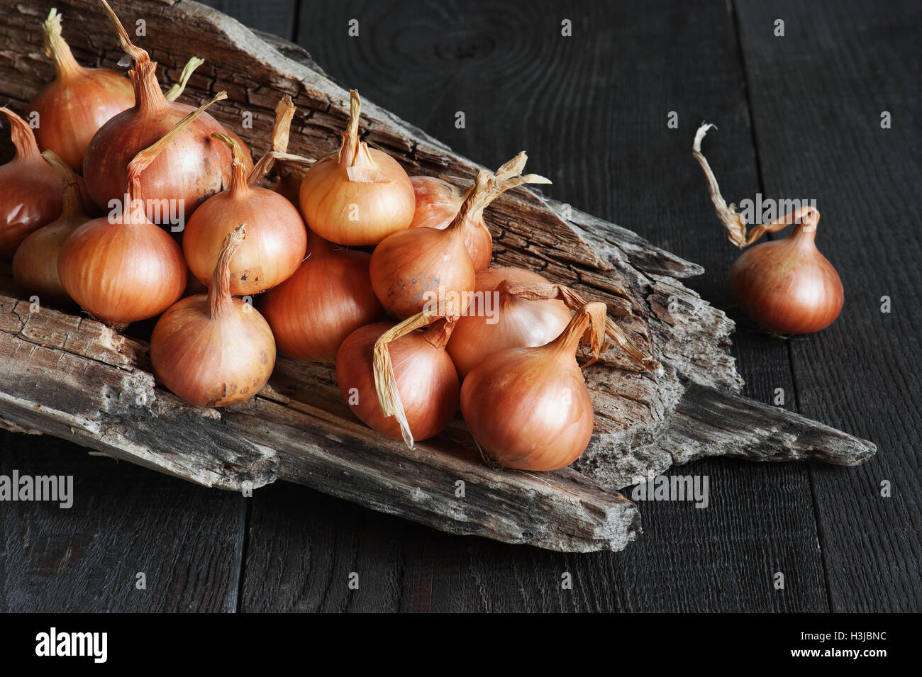 Fresh onions on the dark wooden table Stock Photo - Alamy