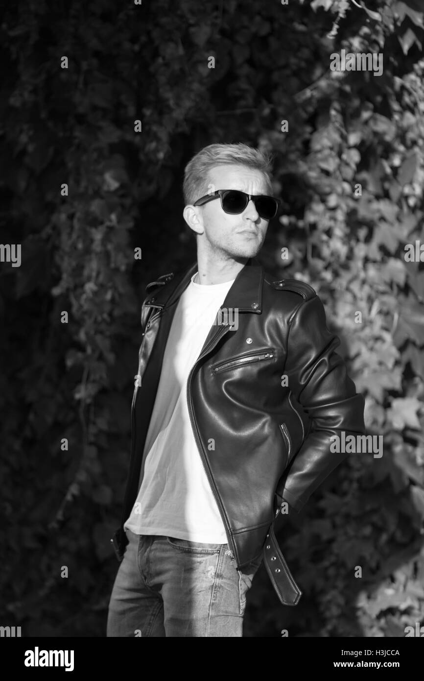 young man posing in leather jacket cool fashionable black and white Stock Photo